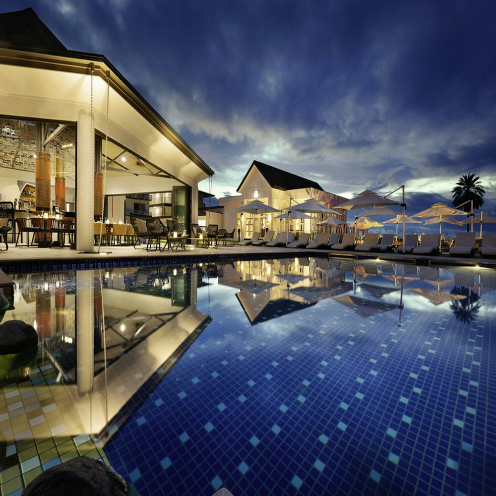 Premium ocean-view resort room with a poolside lounge at dusk